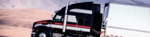 black and orange large volume shipping truck
