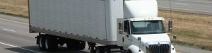 white semi truck traveling freeway